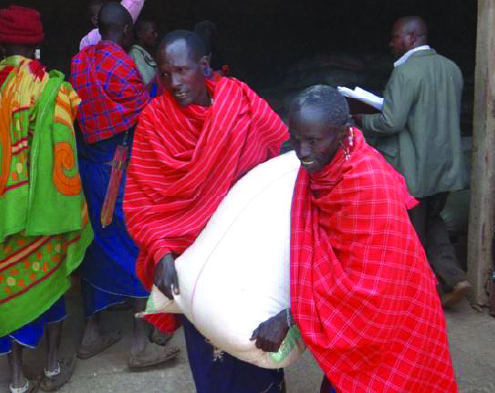 People in red shawls carrying a white sack